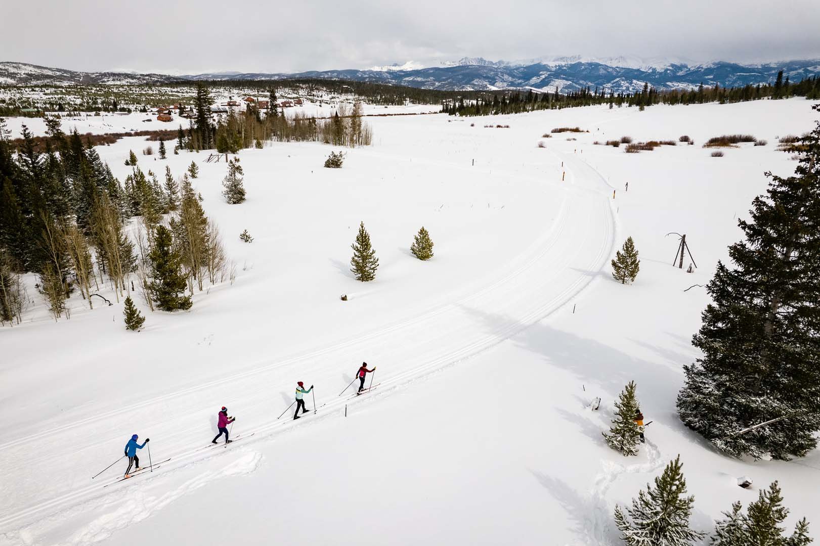 Wide angle of four people cross country skiing