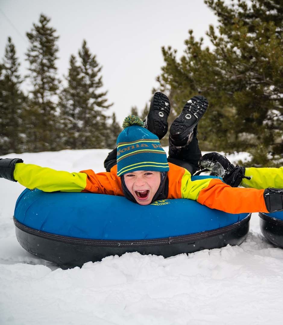 Two kids sledding in the snow