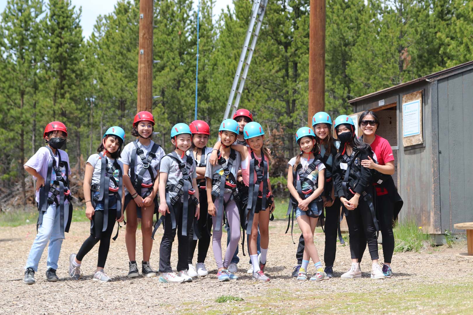 Grupo de niños con cascos y arneses preparados para escalar.