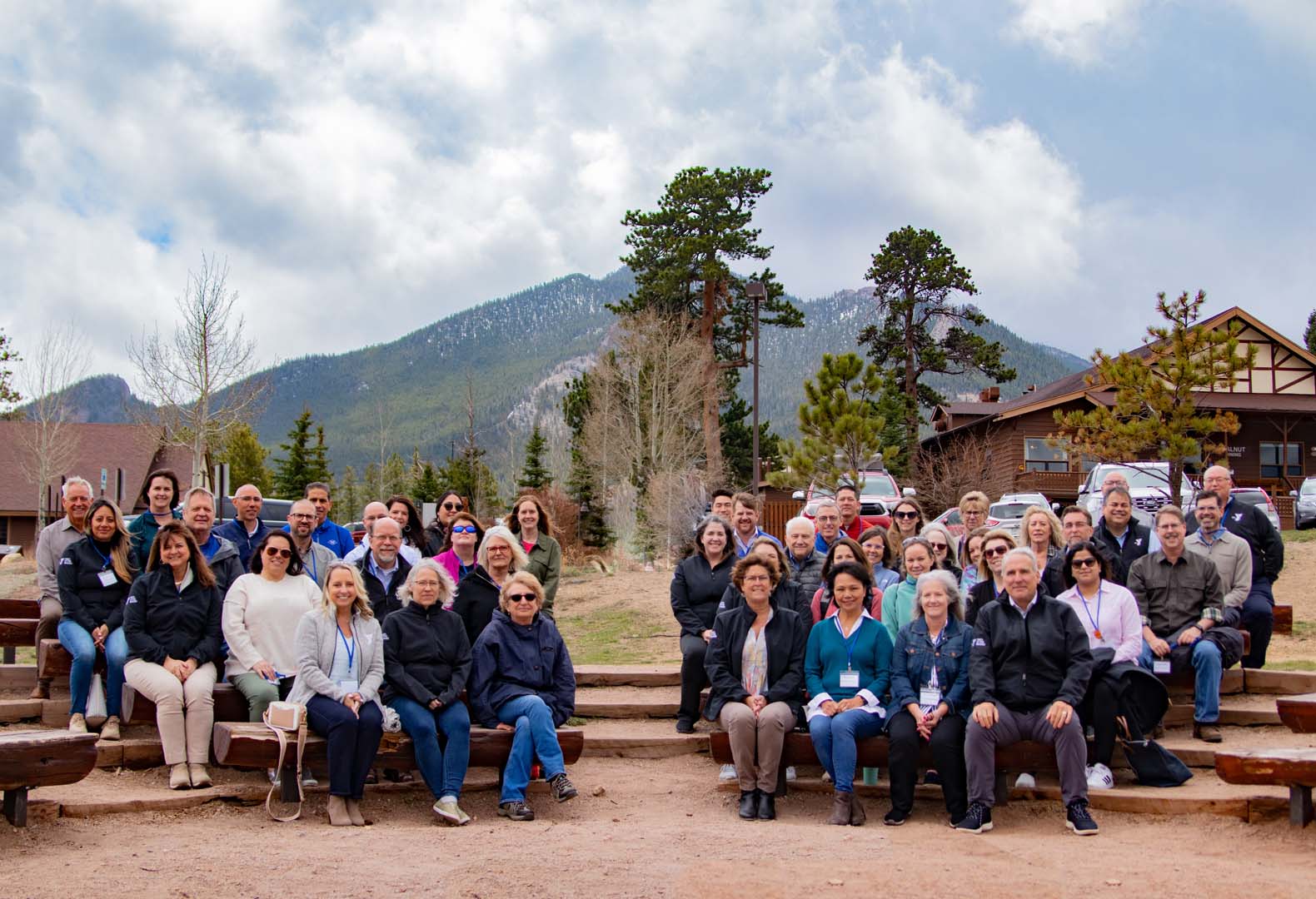 Group of people posing for a photo outside in front of cabins