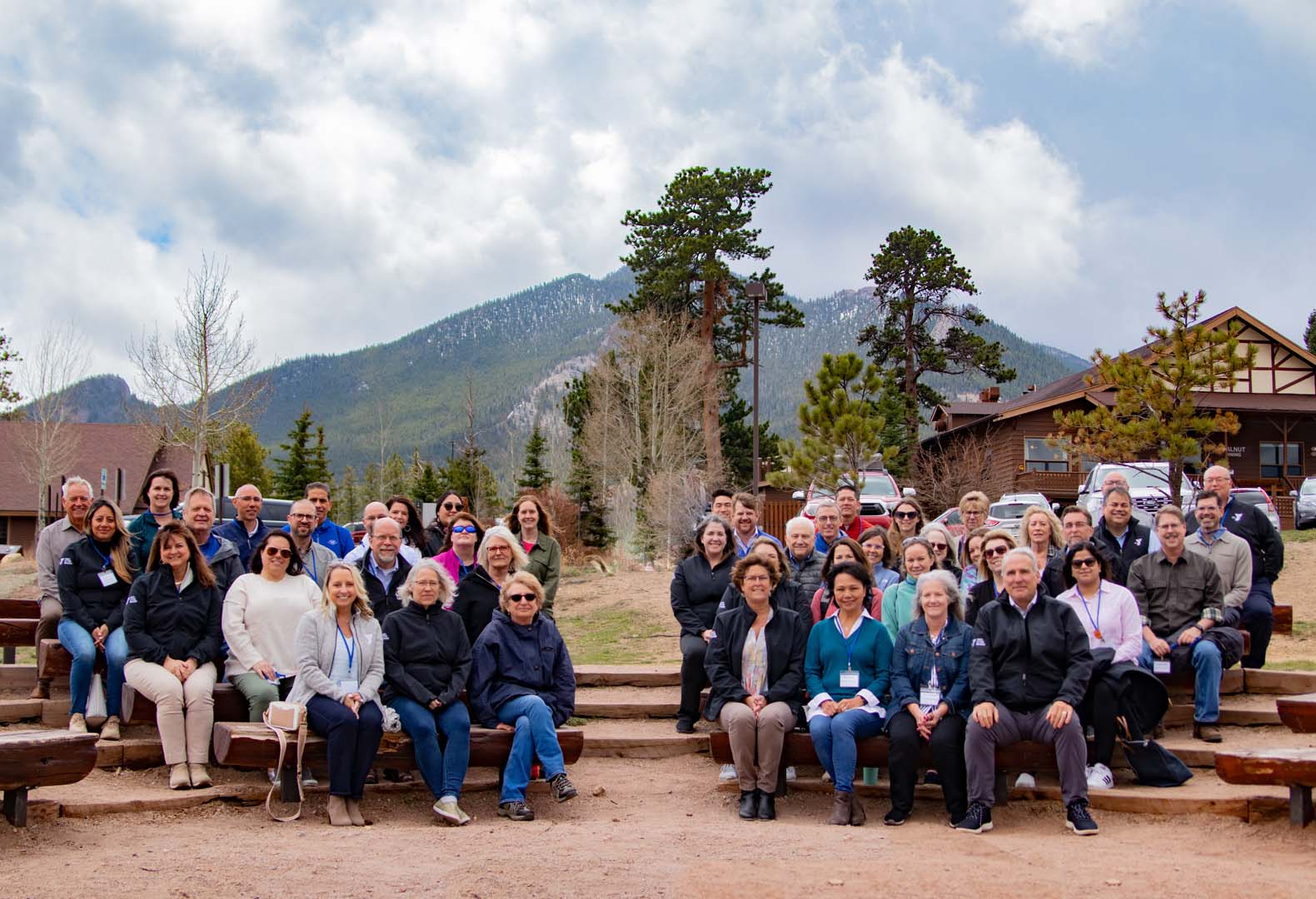 Grupo de personas posando para una foto afuera frente a cabañas