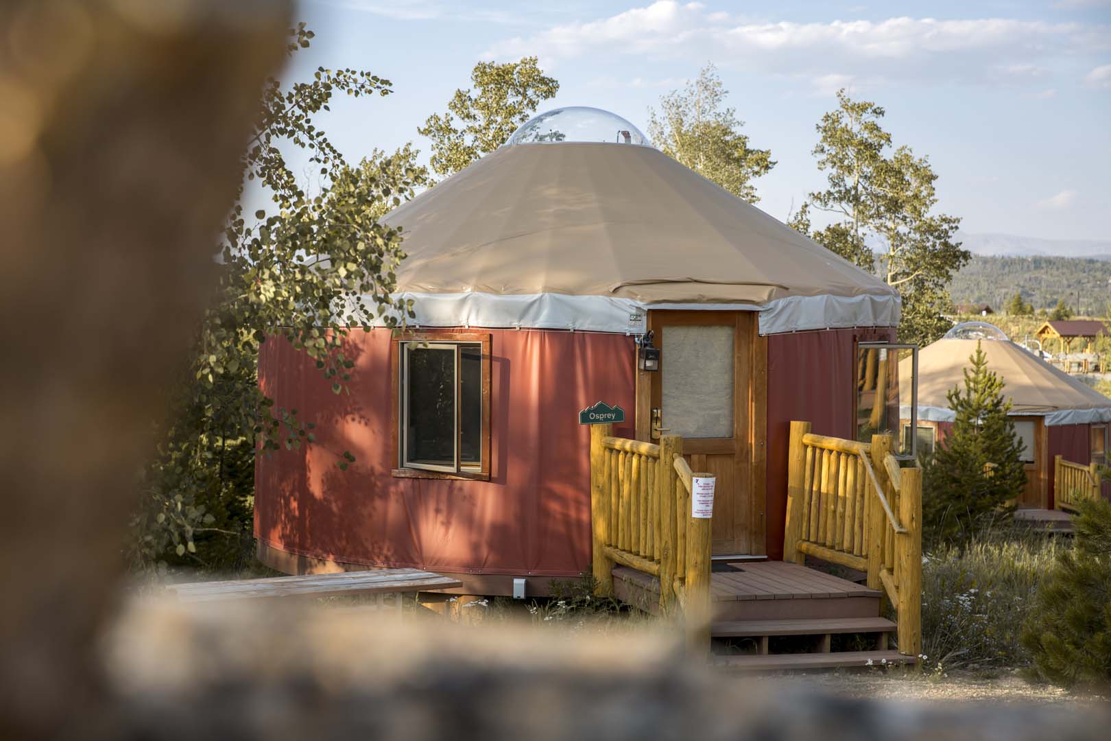 Red yurts surrounded by trees