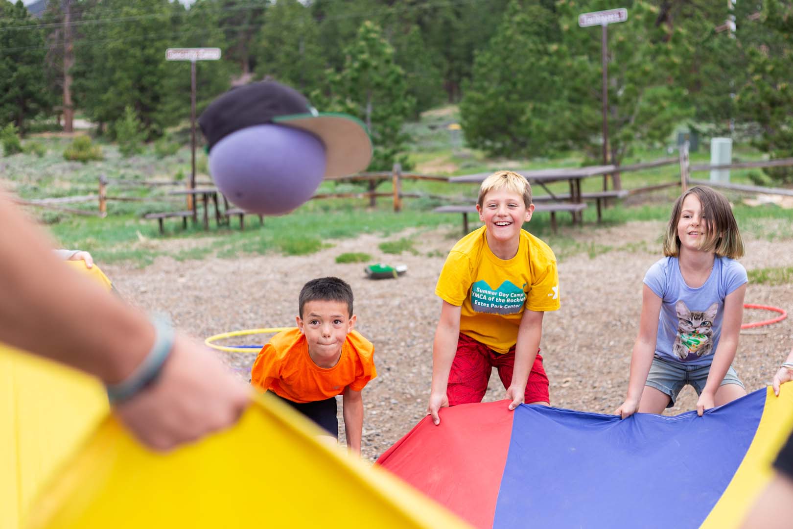 Kids playing outside with a ball and parachute