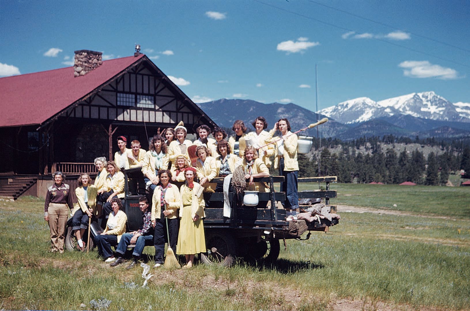 old photo of a group at the YMCA in front of the mountains all wearing yellow