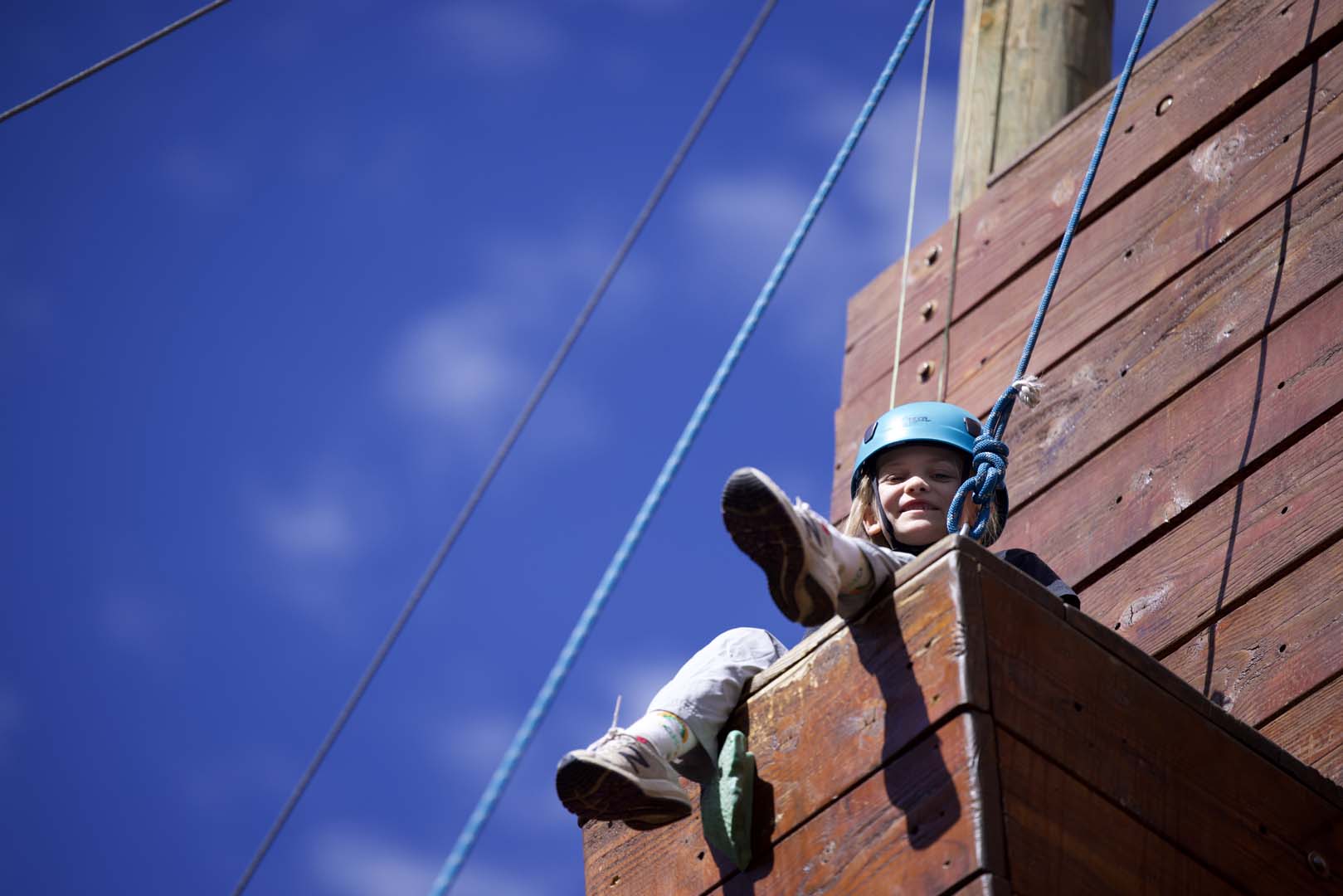 kid looking down at camera from adventure course