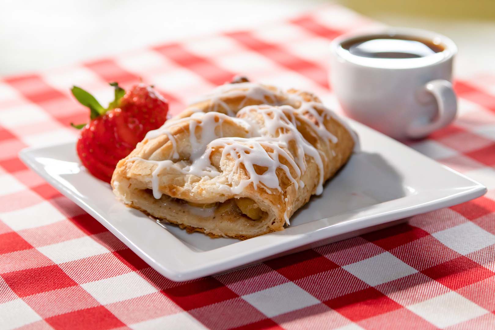 pastry with strawberries and a coffee beside