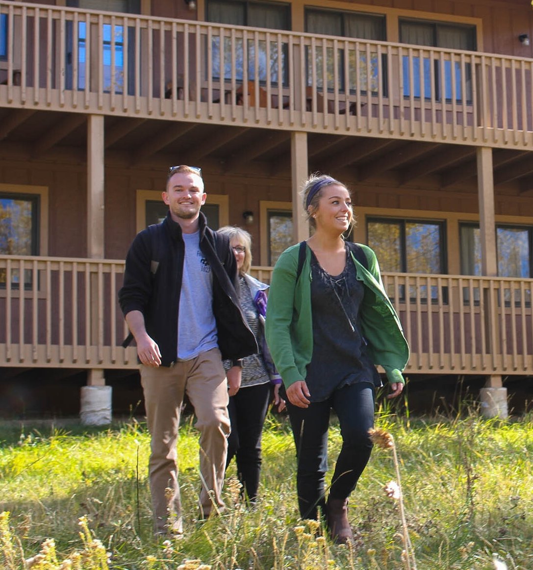 family walking with cabin in the background