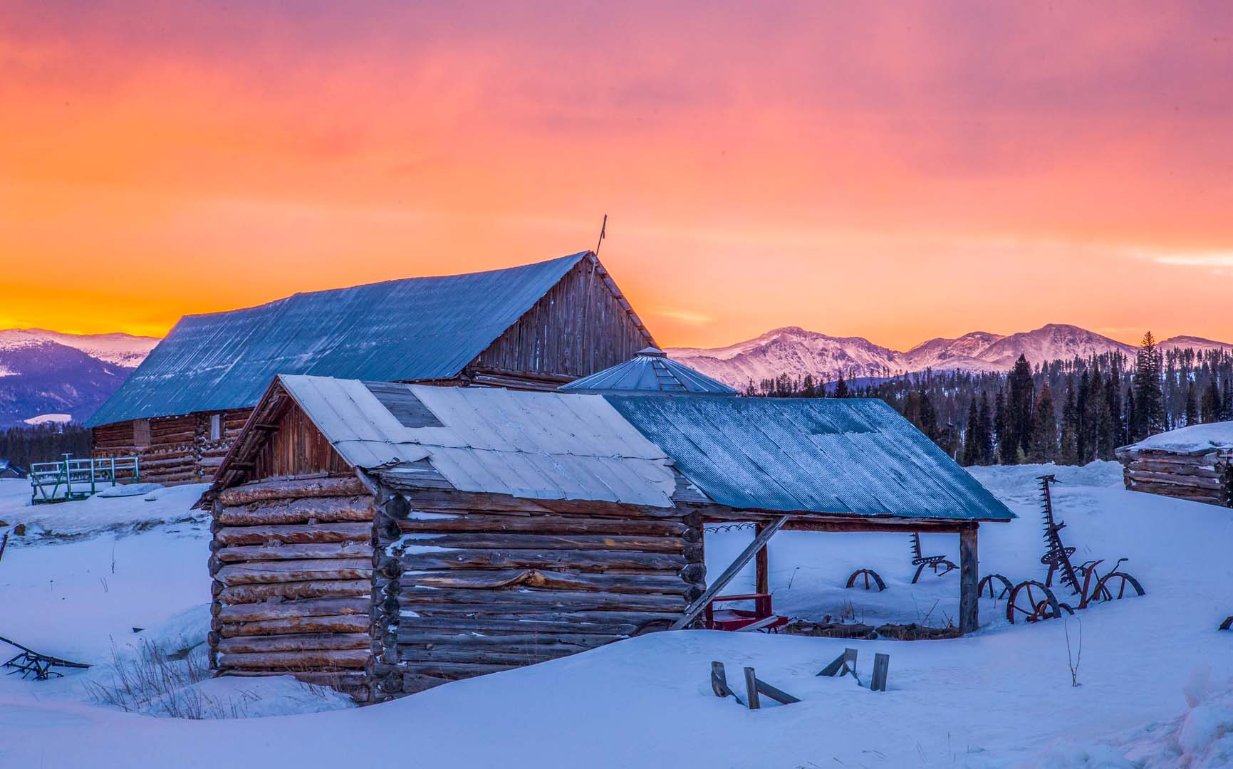 cabaña en la nieve con puesta de sol rosa