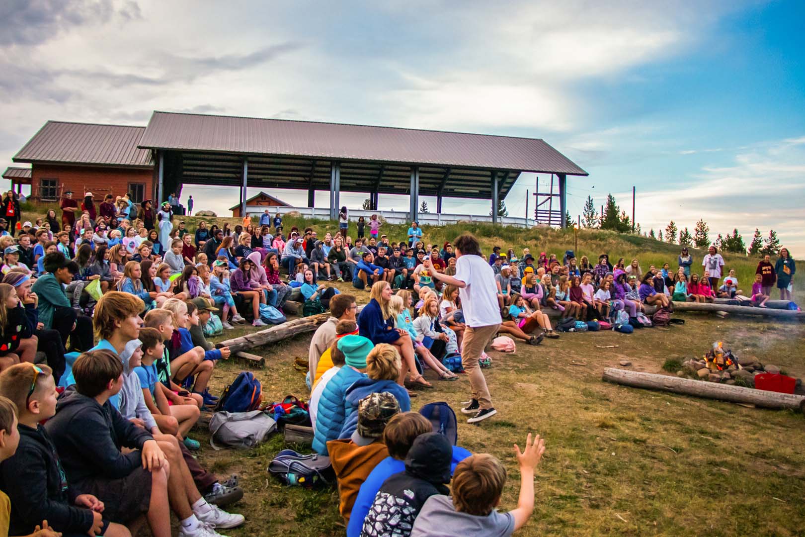 a bunch of kids at camp sittign outside