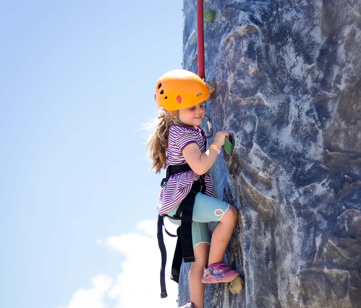 Niña escalando rocas afuera