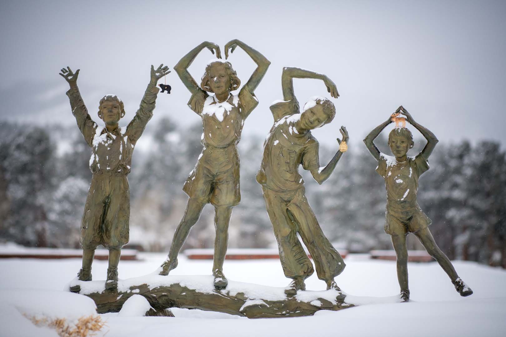 statue of children with snow on it