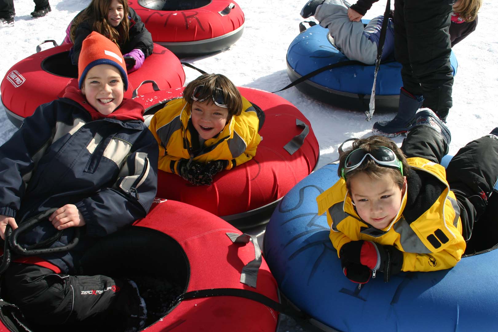 niños haciendo tubing en la nieve