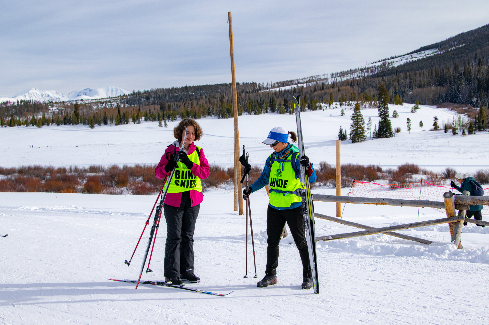 two women skiing with race numbers