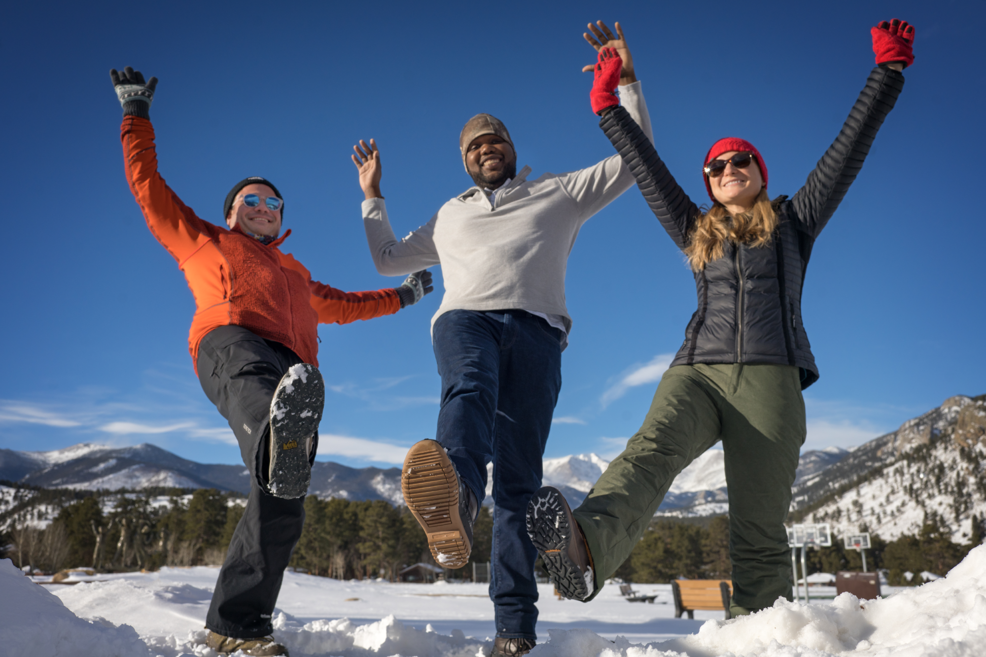 three people celebrating with their arms in the air