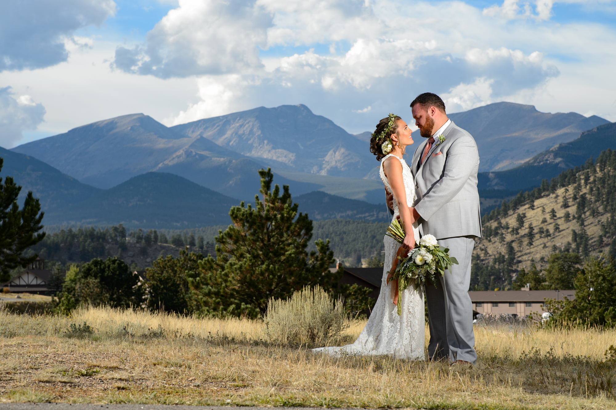 bride and groom embracing with the rockies in the background